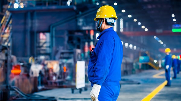 Individual in PPE with LED lighting in the background in a manufacturing environment