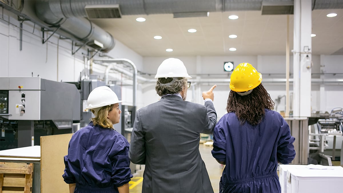 Three people in hard hats inspecting lighting to OSHA standards