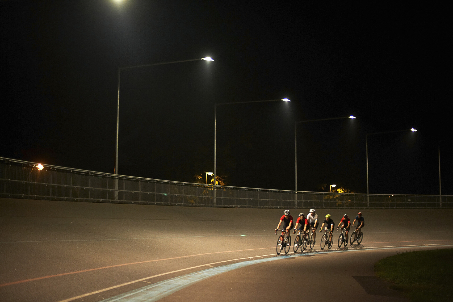 cyclists-riding-together-on-a-track-at-night-2024-07-09-19-55-03-utc (1)