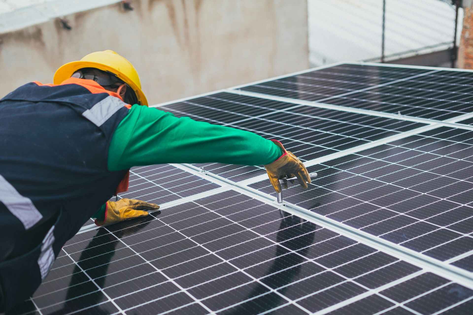 worker mantains solar panel